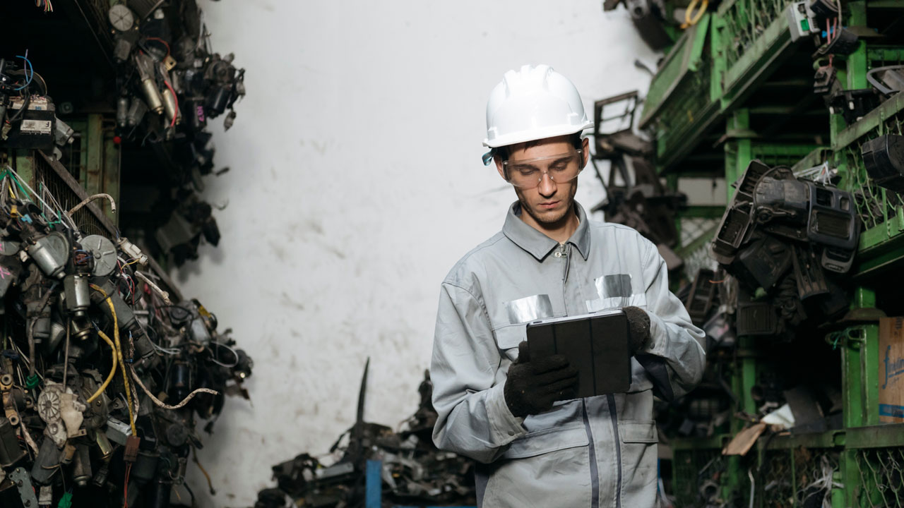 Manufacturing waste reporting systems technician using tablet