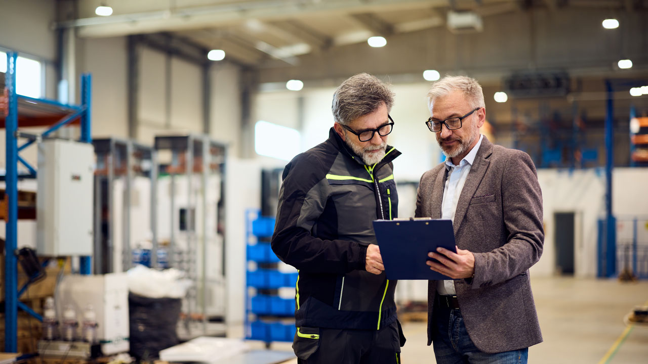 Why regular manufacturing waste reviews improve performance 1 Engineers discussing manufacturing waste review in modern industrial facility